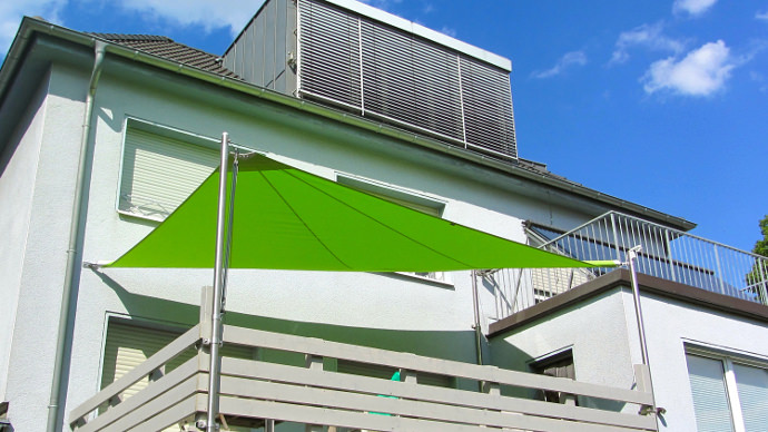 automatisch aufrollbares Sonnensegel in grün auf einem Balkon