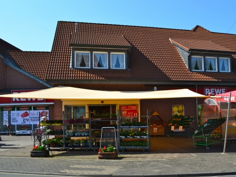 Sonnensegel - elektrisch - in Ascheberg in Gelb vor Supermarkt