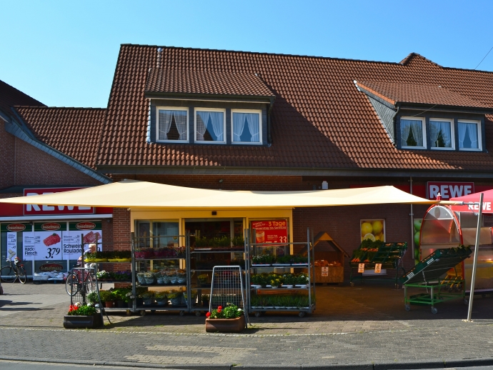 Sonnensegel - elektrisch - in Ascheberg in Gelb vor Supermarkt