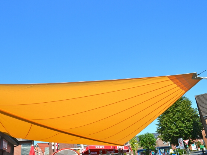 Sonnensegel - elektrisch - in Ascheberg in Gelb vor Supermarkt