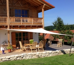 Sonnensegel an einer Terrasse in Bayern am Holzhaus